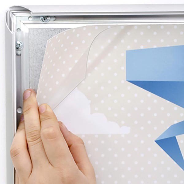 Démonstration du système clic-clac d’un cadre en aluminium argent brossé. Une main soulève le film de protection transparent pour changer l’affiche en quelques secondes. Ouverture frontale ultra rapide, idéal pour cadres étanches, ignifugés ou standard en formats A1 à A4.