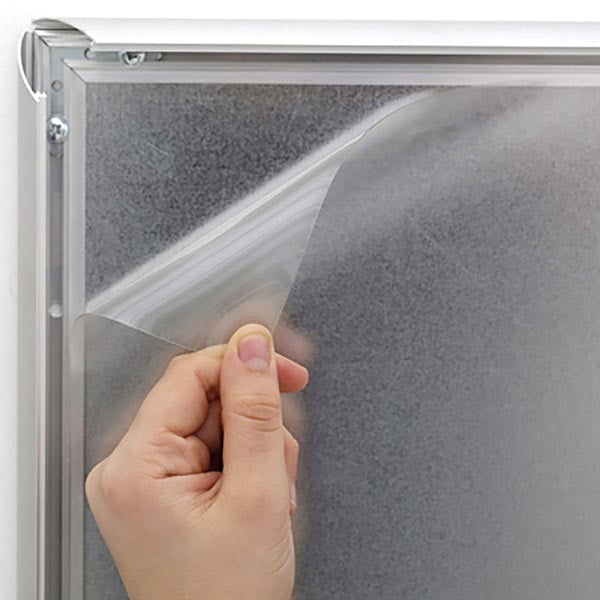 Démonstration du système clic-clac d’un cadre en aluminium argent brossé. Une main soulève le film de protection transparent pour changer l’affiche en quelques secondes. Ouverture frontale ultra rapide, idéal pour cadres étanches, ignifugés ou standard en formats A1 à A4.
