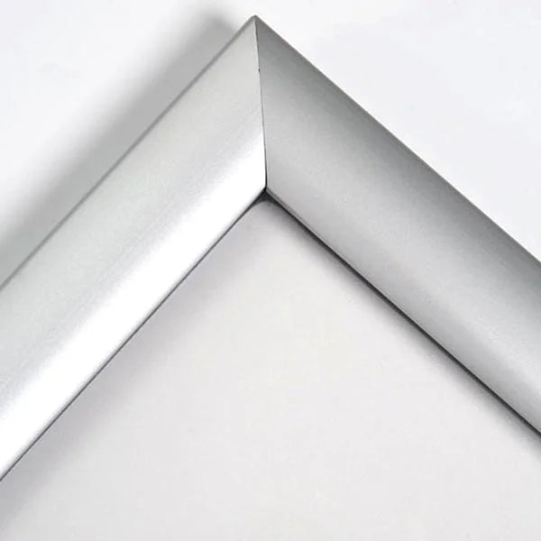 Gros plan sur l’angle d’un cadre clic-clac en aluminium brossé argent de 25 mm de largeur. Assemblage précis et finition haut de gamme, idéal pour cadres étanches et résistants à l’humidité en formats A1 à A4.