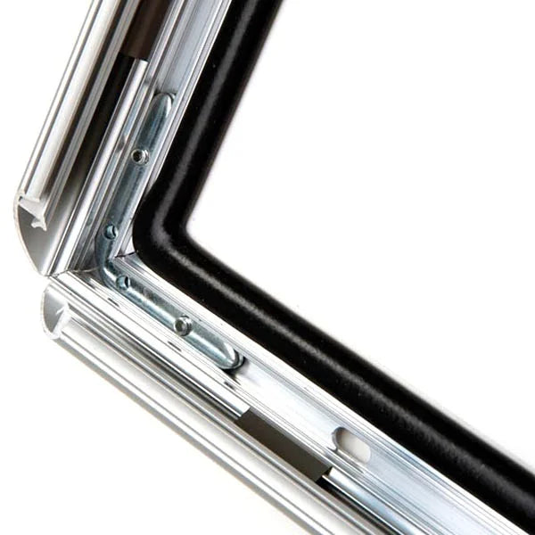 Gros plan sur le coin d’un cadre clic-clac étanche en aluminium argent. On voit le joint noir d’étanchéité, le profil robuste et le système de fixation à ressort pour une ouverture frontale ultra rapide. Conception 100% étanche pour usage extérieur ou milieux humides.