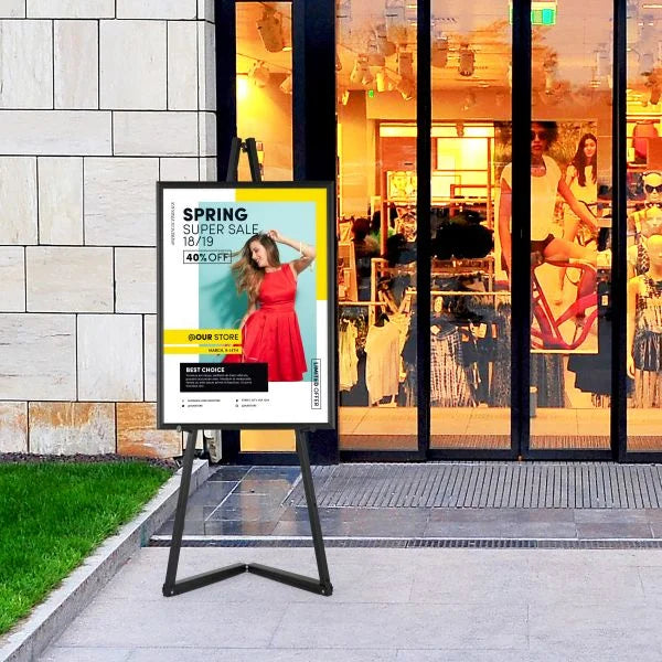 Chevalet porte affiche A1 en aluminium noir installé devant un magasin