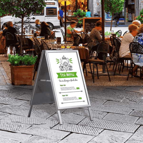 Chevalet stop trottoir en aluminium avec affiche menu installé devant un restaurant