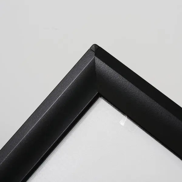 Détail du coin du cadre aluminium noir d’un panneau stop trottoir publicitaire